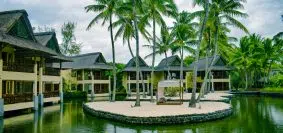 brown and white wooden house near body of water during daytime