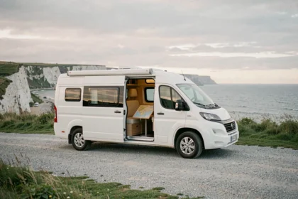 Camping-car blanc stationné sur une aire face aux falaises d'Ault avec vue sur la Manche