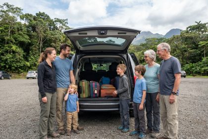 Famille multigenerational chargant valises dans un van