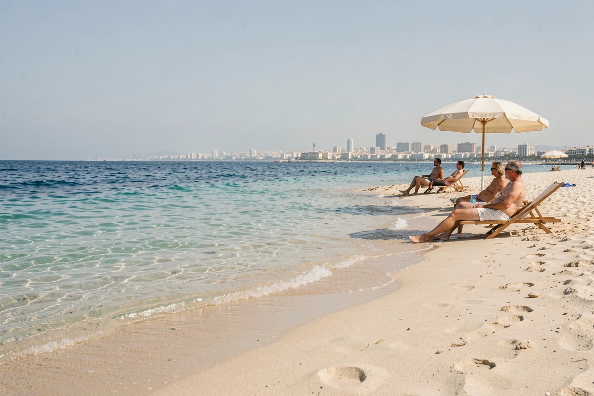 Plage de sable près d'Héraklion avec vue sur la ville et vacanciers se reposant sous un parasol