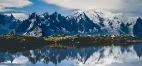 snow covered mountain near lake during daytime